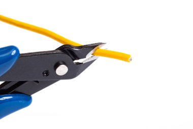 Blue wire cutter cuts yellow wire isolated on white background