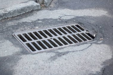 Yolda bir rögar kapağının metal ızgarası. Yaklaş.