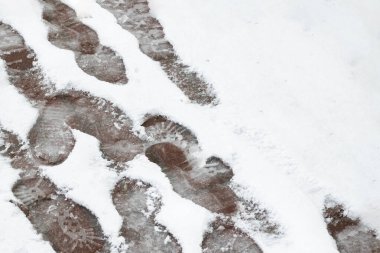 Kaldırımdaki ıslak karda ayak izleri. Yaklaş.