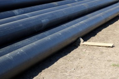 Çimlerin üzerinde katlanmış su boruları için siyah metal borular.