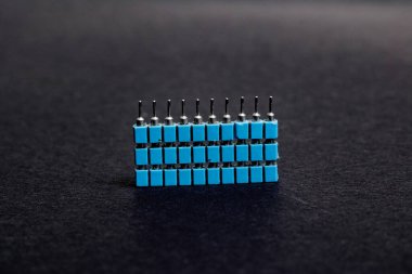 Siyah arkaplanda mavi elektronik mühendislik konnektörleri yığını