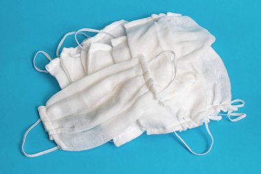 Mavi arka planda gazlı bez maskesi yığını.