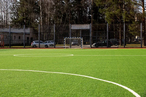 Groen voetbalveld achter het hek close-up — Stockfoto