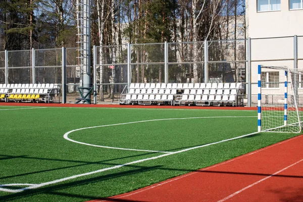 Green soccer field behind the fence closeup — Stock Photo, Image