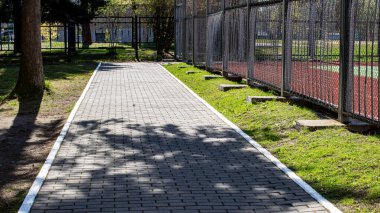 Parktaki döşeme sokağı güneş ışığıyla kapanıyor.