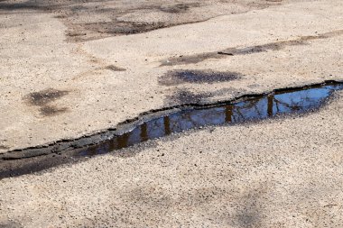 Yoldaki kaldırımda bir delik. Yaklaş.