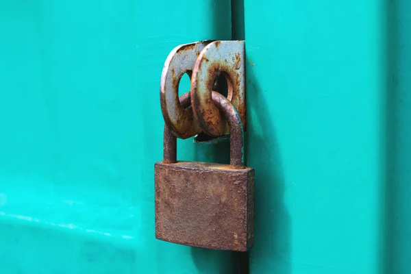 Gammal rostig hänglås på en grön dörr — Stockfoto