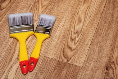 Ahşap bir masa üzerinde iki sarı boya fırçası fotokopi alanı