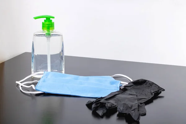 テーブルの上に消毒剤と医療用マスク付きボトル — ストック写真