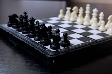 Siyah ahşap arka planda aralıklı satranç. Yakın plan.