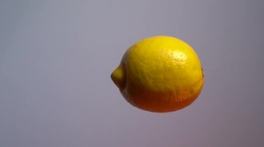 Limon. Havada yüzen ve dikey eksen etrafında dönen bir limon meyvesinin videosu.