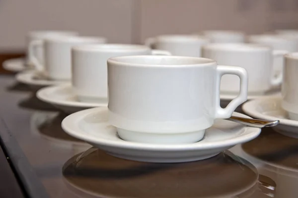 Крупним планом брудна чашка кави і ложка встановлюються на білій тарілці і дерев'яний стіл після випивання вранці в старовинному стилі. чашка — стокове фото
