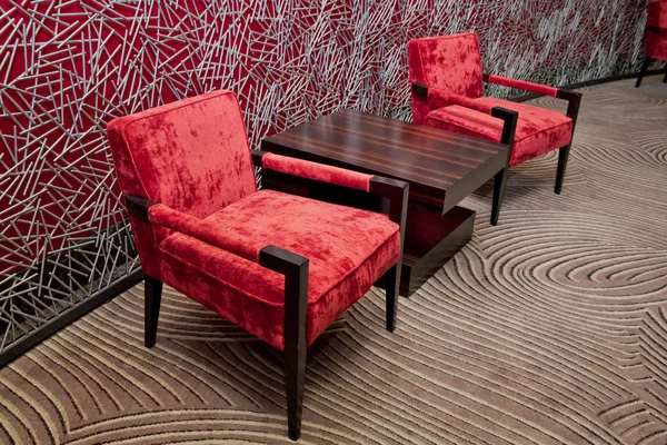 Fauteuil in de lobby van het hotel. Interieur van modern hotel. Rode lederen en luxe stoelen. — Stockfoto