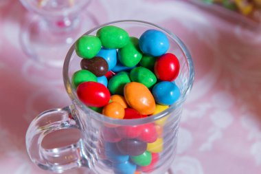 Renkli şeker. Çok tatlılar renkli. Renkli şeker bir cam. Yuvarlak çikolata çok renkli