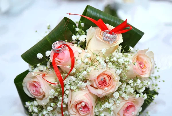 Ramo de flores de boda y compromiso blanco. Hermoso ramo de bodas con diferentes flores, rosas. anillos de boda y detalles de la boda. Cinta de boda — Foto de Stock