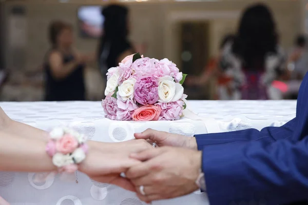 Verlobungsblüte. das Mädchen und der Junge nahmen sich gegenseitig die Hände. Verlobungen auf dem Hintergrund von Blumen. rosa Blüten — Stockfoto