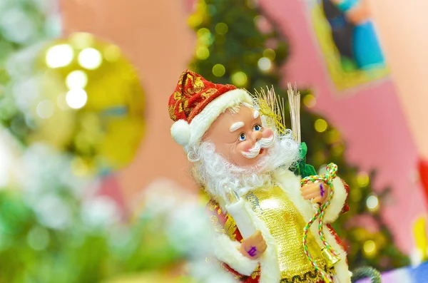 Weihnachtsmann-Puppe Weihnachtsmann-Spielzeug Weihnachtsmann sitzt auf einem Tannenzweig — Stockfoto