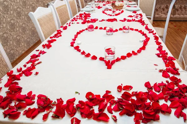 Red Hot ibišek čaj ve skleněné hrnek na dřevěný stůl mezi okvětními lístky růží a suchý čaj pudinku se srdcem — Stock fotografie