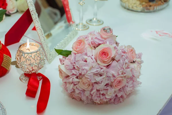 Свадебный букет из розовых роз и обручальных колец на деревянном столе. Принято. Концепция свадьбы, вечеринки, любви и семьи и колец — стоковое фото