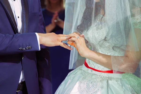 Plan rapproché de la main du marié mettant une alliance sur le doigt de la mariée. Main gauche. rite catholique — Photo