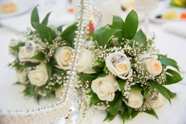 Mooie witte bruiloft boeketten in mand backgraound boeket bloemen roze trouwringen — Stockfoto