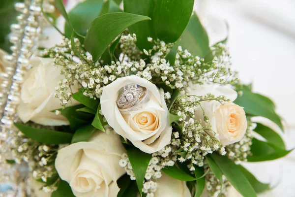Mooie witte bruiloft boeketten in mand boeket bloemen roze trouwringen — Stockfoto
