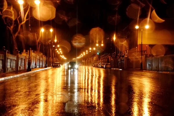 Las calles lluviosas de Bakú. Noche lluviosa en la ciudad de Bakú, los faros de los coches brillan a través de la niebla. Vista de cerca desde el nivel de la línea divisoria, enfoque selectivo — Foto de Stock