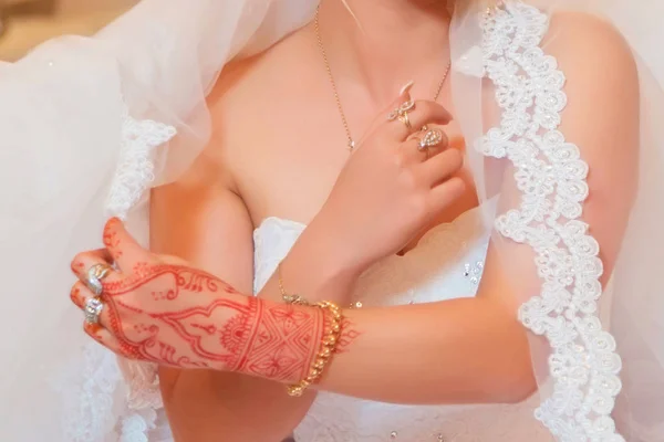 A noiva segura a gordura. A noiva tem auscultadores, anéis e pulseiras. Noivas mãos com anel mostrando. Elegante anel de casamento com bela hena de mão da noiva — Fotografia de Stock