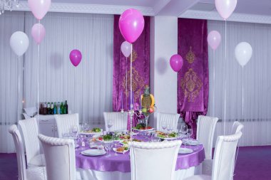 Zarif yemek masası. Düğün masa mumlarla süslenmiş, çatal bıçak takımı ve çanak çömlek ile servis ve bir masa örtüsü ile kaplı. Pembe masa örtüsü. Beyaz sandalyeler. Beyaz düğün tablo. Dekore edilmiş bir tablo