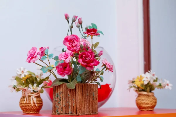 Vasos de flores de madeira e rosas de ouro vermelho. Bela planta de madeira rosa ranúnculo em vaso no fundo branco — Fotografia de Stock