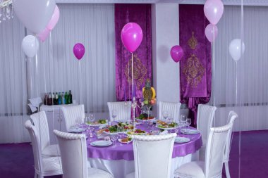 Zarif yemek masası. Düğün masa mumlarla süslenmiş, çatal bıçak takımı ve çanak çömlek ile servis ve bir masa örtüsü ile kaplı. Pembe masa örtüsü. Beyaz sandalyeler. Beyaz düğün tablo.