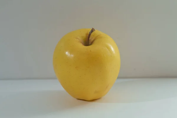 在白色背景查出的金苹果美味。剪裁路径。全场深度。新鲜的苹果查出在白色背景。成熟的细长明亮的绿色, 带有黄色的色彩和棕色的点苹果 — 图库照片