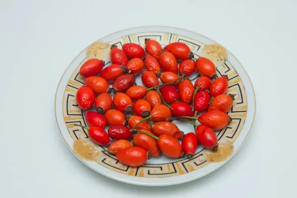 L'églantier dans l'assiette. Vue du dessus des hanches de rose dans un bol isolé sur blanc. Hanche rose — Photo