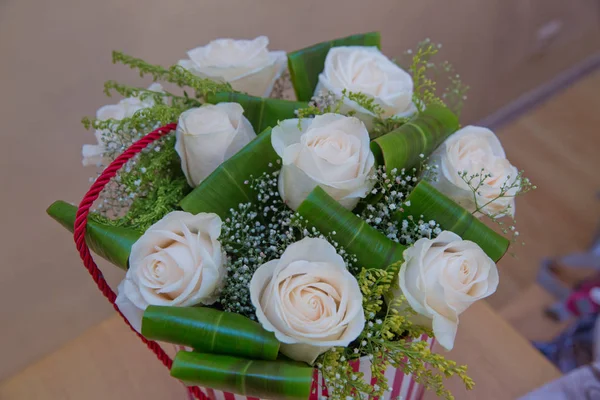 Mooie bloemboeket van witte rozen in grote ronde rode hoed vak. Werk de bloemist. Mother's Day — Stockfoto