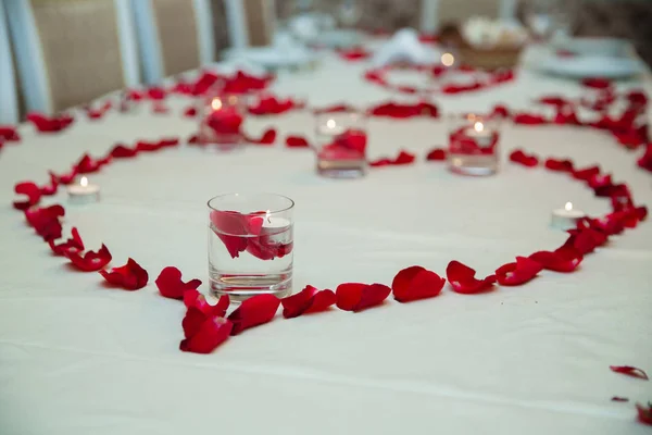 Red Hot ibišek čaj ve skleněné hrnek na dřevěný stůl mezi okvětními lístky růží a suchý čaj pudinku se srdcem — Stock fotografie