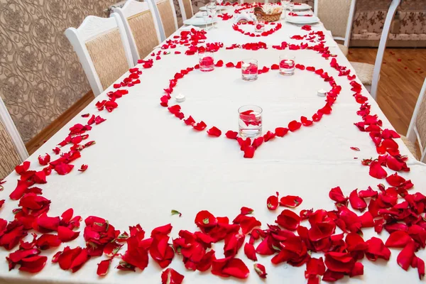 Red Hot Hibiscus thee in een glazen mok op een houten tafel onder rozenblaadjes en droge thee vla met hart — Stockfoto