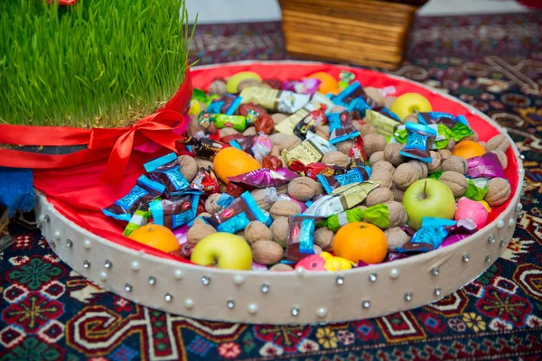 Nasienny podłogi na czerwoną wstążką na suchej trawy. Novruz krajowe Azerbejdżan wakacje wiosna nowy rok uroczystości koncepcja, semeni trawa pszenicy. — Zdjęcie stockowe