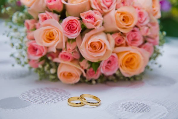 Bruids boeket met oranje en roze rozen van verschillende grootte met handvat op witte achtergrond. Bruiloft boeket met prachtige bloemen. Twee ringen vertegenwoordigen de betekenis van gevoel liefde. Selectieve aandacht — Stockfoto