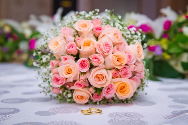 Bruids boeket met oranje en roze rozen van verschillende grootte met handvat op witte achtergrond. Bruiloft boeket met prachtige bloemen. Twee ringen vertegenwoordigen de betekenis van gevoel liefde. Selectieve aandacht — Stockfoto