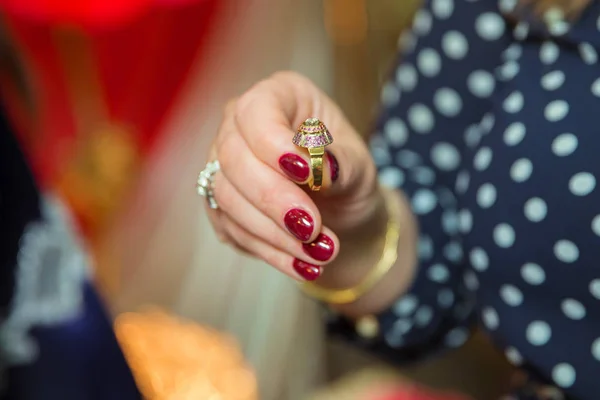 Mujer sosteniendo un anillo en su mano, la imagen tiene una profundidad de campo poco profunda por lo que su cara no es reconocible — Foto de Stock