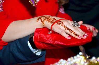 Elleri ve parmakları çizilir kına için. El ile kına dövmesi. Yumuşak seçici odak, yakın. Kırmızı lak ve çivi halkaları vardır. Gelinin ellerin adamlar ellerinde