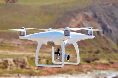 Drone dört helikopter gökyüzü üzerinde yüksek çözünürlüklü dijital kamera ile. Beyaz drone ile dijital fotoğraf makinesi dağ Drone ile yüksek çözünürlüklü dijital fotoğraf makinesi üzerinde gökyüzünde uçan.