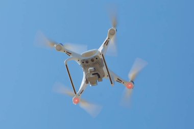 Drone dört helikopter gökyüzü üzerinde yüksek çözünürlüklü dijital kamera ile. Beyaz drone ile dijital fotoğraf makinesi dağ Drone ile yüksek çözünürlüklü dijital fotoğraf makinesi üzerinde gökyüzünde uçan. dron, alttan görünüm