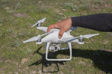 Beyaz drone ile dijital fotoğraf makinesi dağ Drone ile yüksek çözünürlüklü dijital fotoğraf makinesi üzerinde gökyüzünde uçan. Işleç dron yerde oluşturur. Işleç beyaz dron tutar