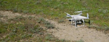Beyaz drone ile dijital fotoğraf makinesi dağ Drone ile yüksek çözünürlüklü dijital fotoğraf makinesi üzerinde gökyüzünde uçan. Uçmaya hazırlanıyor çim kamera ile robot. Mavi gökyüzü arka plan kontrol ile uçan uçak