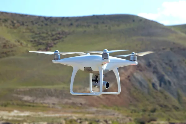 Drone quad copter con cámara digital de alta resolución en el cielo. Drone blanco con cámara digital volando en el cielo sobre la montaña Drone con cámara digital de alta resolución . —  Fotos de Stock