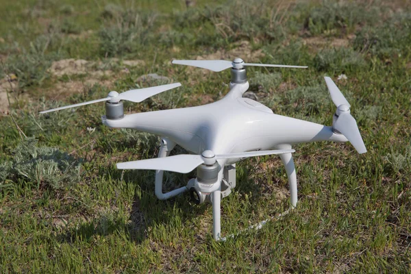 Drone blanco con cámara digital volando en el cielo sobre la montaña Drone con cámara digital de alta resolución. Drone con cámara en la hierba preparándose para volar  . —  Fotos de Stock
