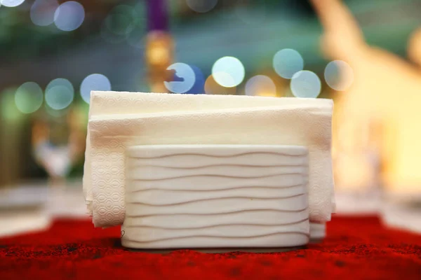 Mesa de comedor del hotel con servilleta decorativa, vajilla de vidrio en el comedor del hotel. Imagen borrosa. La servilleta de papel blanco se coloca en un vaso sobre la mesa en la sala de banquetes. . —  Fotos de Stock