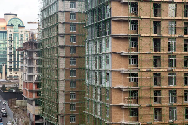 Gran obra de construcción que incluye varias grúas que trabajan en un complejo de edificios. Trabajando en una obra de construcción. Se está construyendo un nuevo edificio . — Foto de Stock