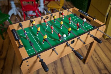 Masa futbolu. Çocuk oyun odasında langırt. Maç sırasında yakın çekim. Futbol masası çocuğunun ev oyuncakları, futbol aile oyun masası oyuncakları çocuk tahtaları. .